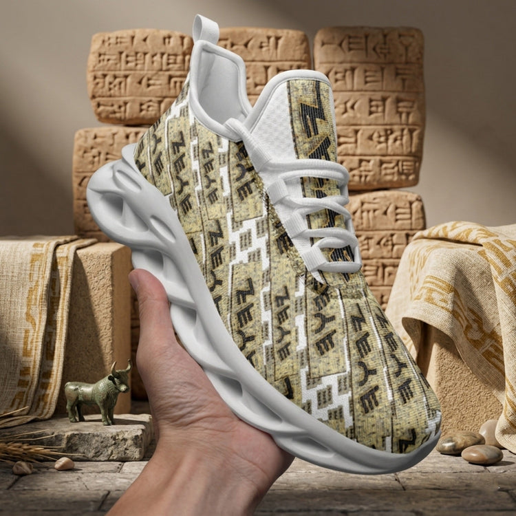 A person holding a white and tan athletic sneaker patterned with ancient cuneiform script, set against a background of clay tablets.
