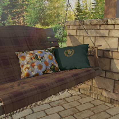 The Dawning Field rectangular lumbar outdoor pillow with daisy artwork resting beside an embroidered TRP accent pillow on a patio swing.