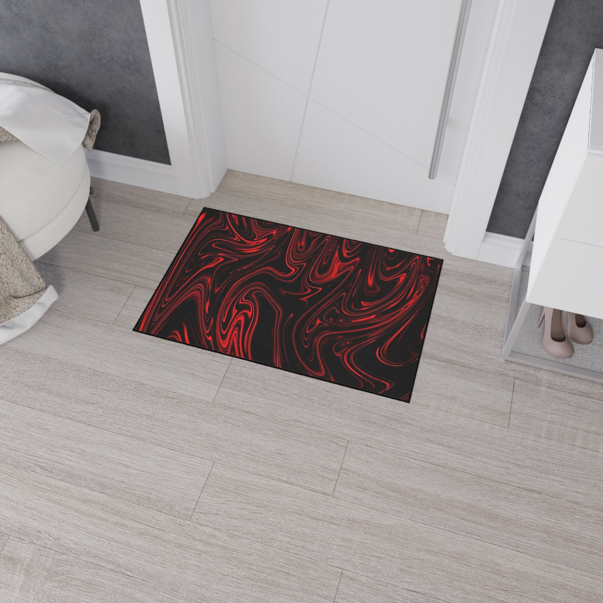 Black doormat with red abstract design on a wooden floor