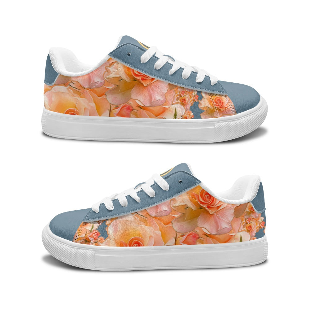 A pair of low-top sneakers shown from the side, featuring a dusty blue suede-like upper with a large peach and orange floral print across the side panels, white laces, and white rubber soles on a white background.