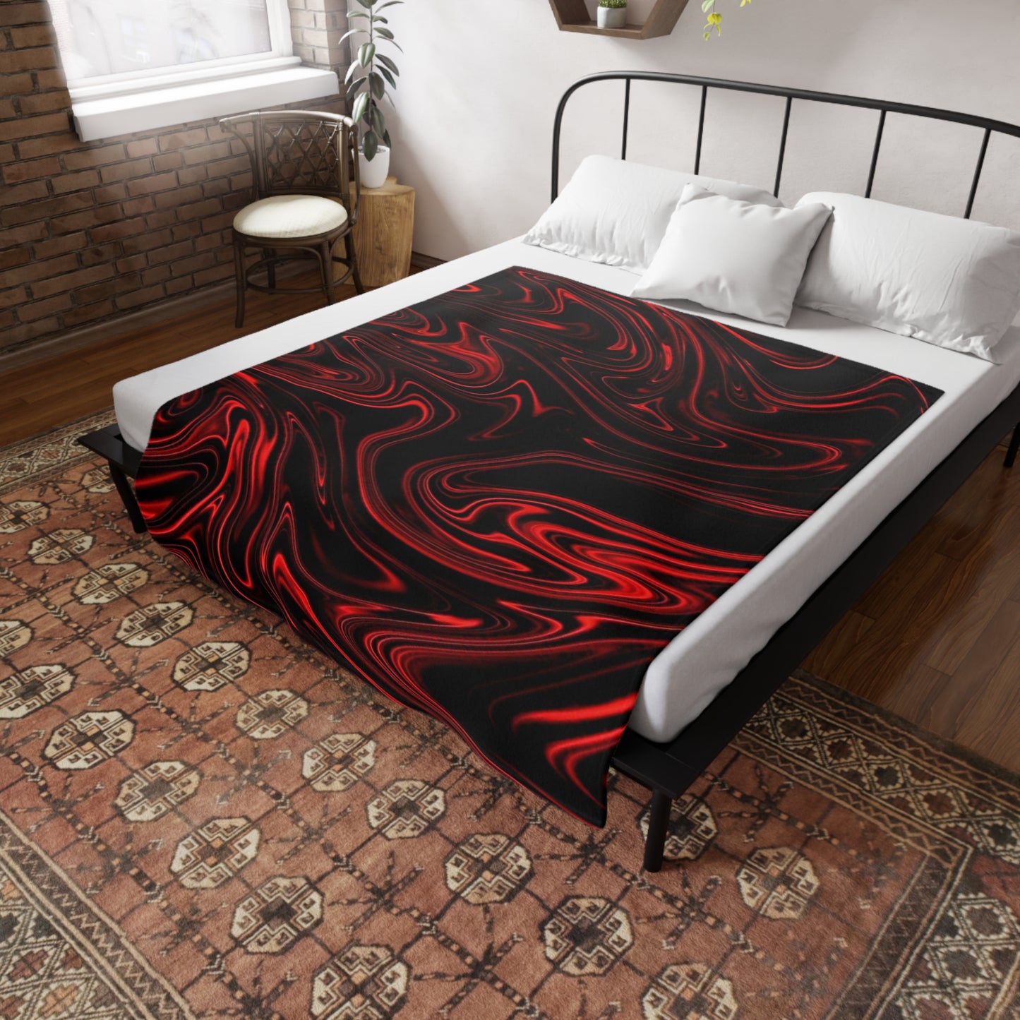 A black bed throw with a red liquid marble pattern draped over a white-sheeted bed in a rustic, brick-walled bedroo