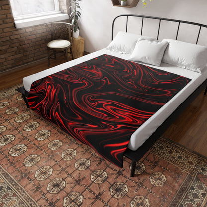 A black bed throw with a red liquid marble pattern draped over a white-sheeted bed in a rustic, brick-walled bedroo