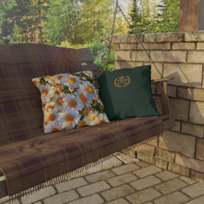 The Dawning Field large square outdoor pillow displayed on a hanging porch swing alongside a dark green TRP crest pillow.