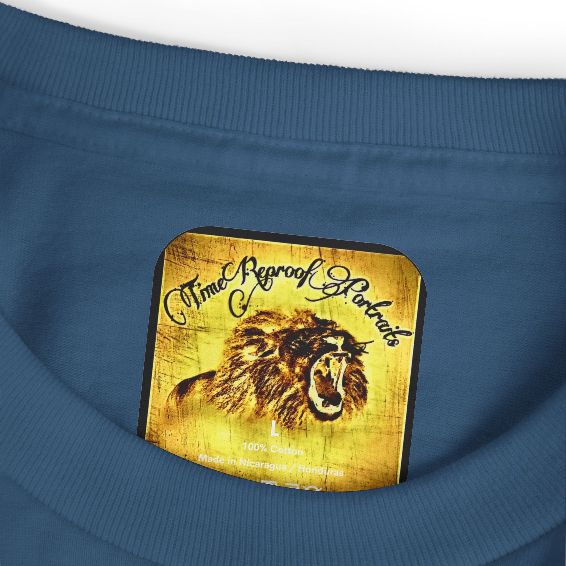 Close-up of branded TimeReproofPortraits lion inside neck tag on faded navy cotton t-shirt.