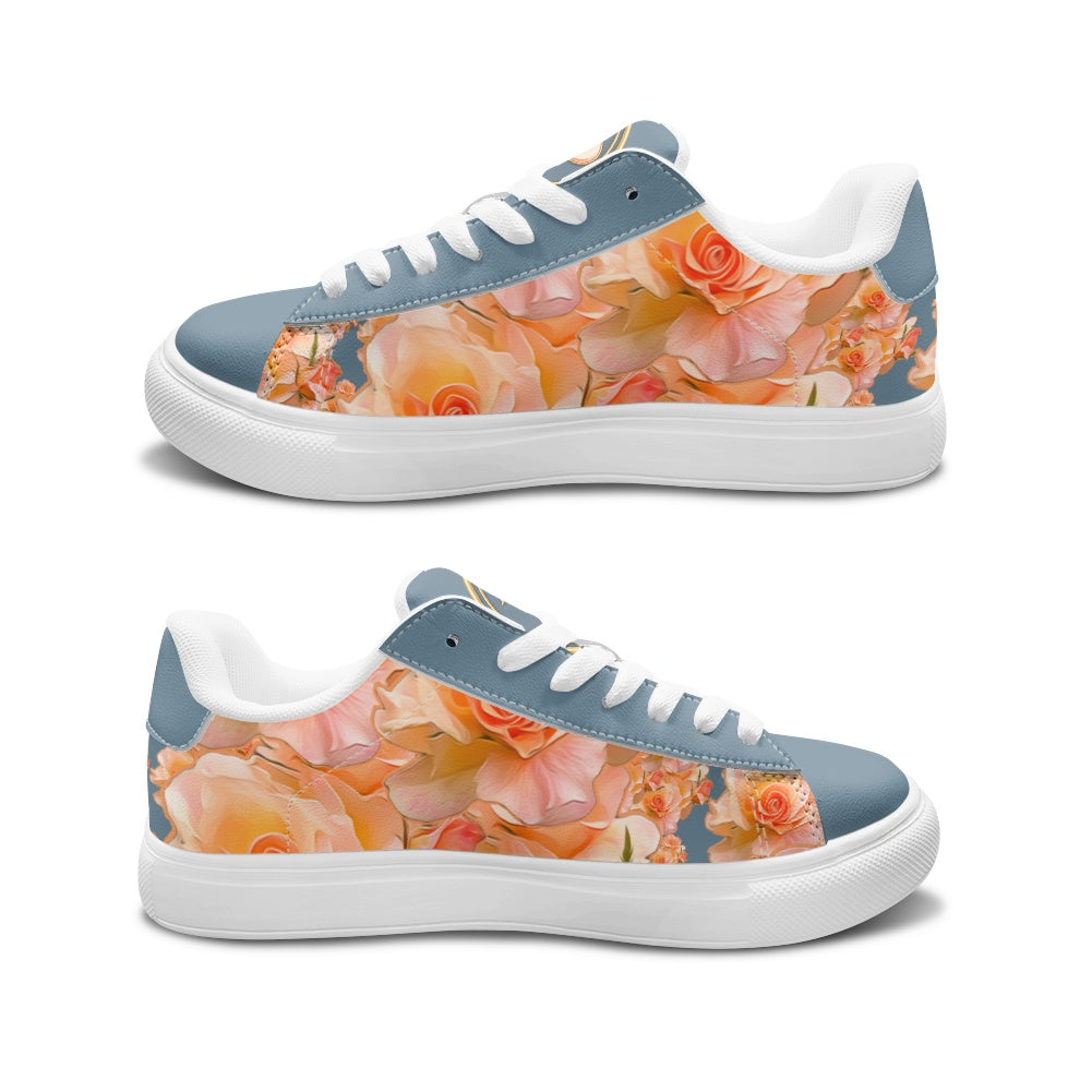 A pair of low-top sneakers shown from the side on a white background. The shoes feature a dusty blue suede-like toe and heel section, a floral print in peach, orange, and pink across the sides, white laces, and white rubber soles.