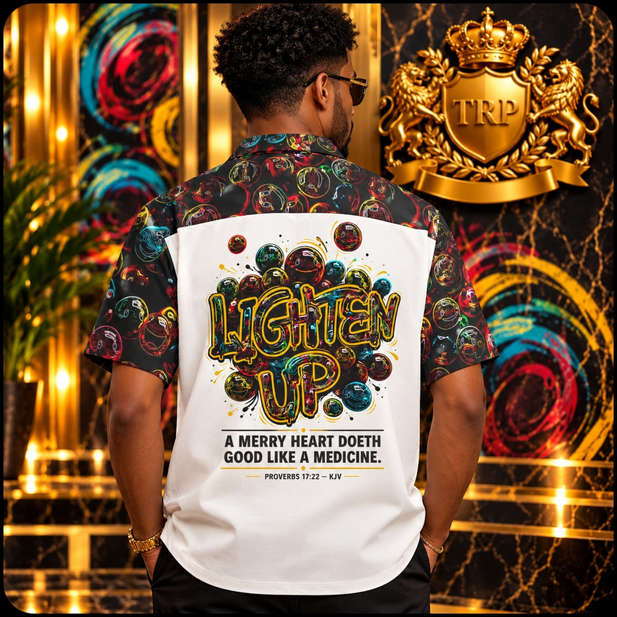 Back of Lighten Up camp-collar shirt on model showing colorful graphics and Proverbs 17:22 quote.