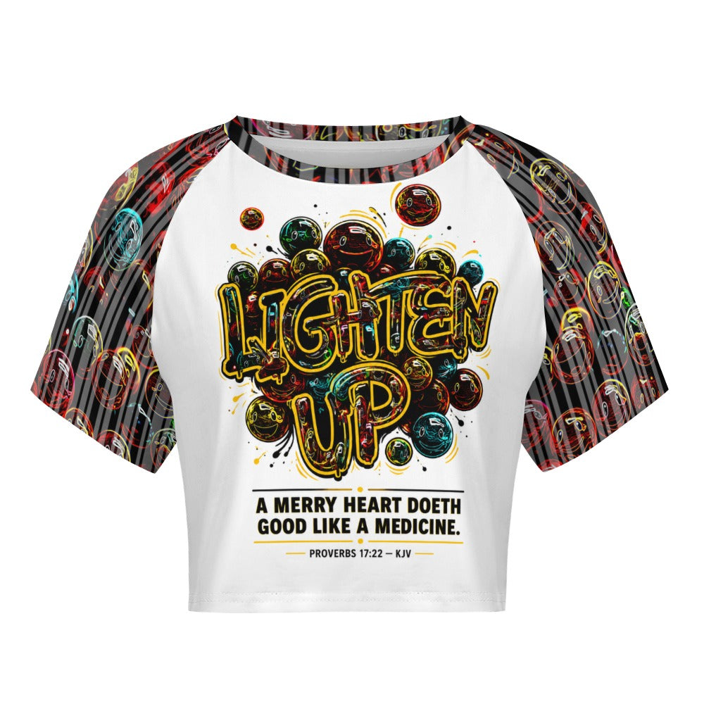 Front view of the Lighten Up raglan crop top with printed scripture Proverbs 17:22 and patterned sleeves.