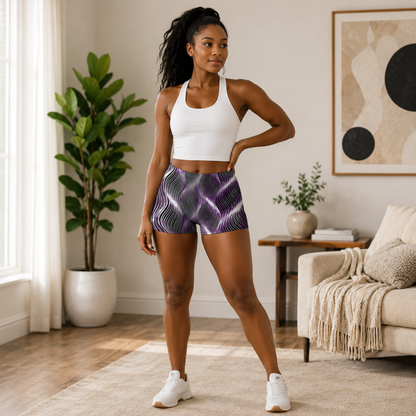A woman in a living room modeling the front view of the OR ARGAMAN Royal Light purple and black wavy patterned legging shorts with a white top.