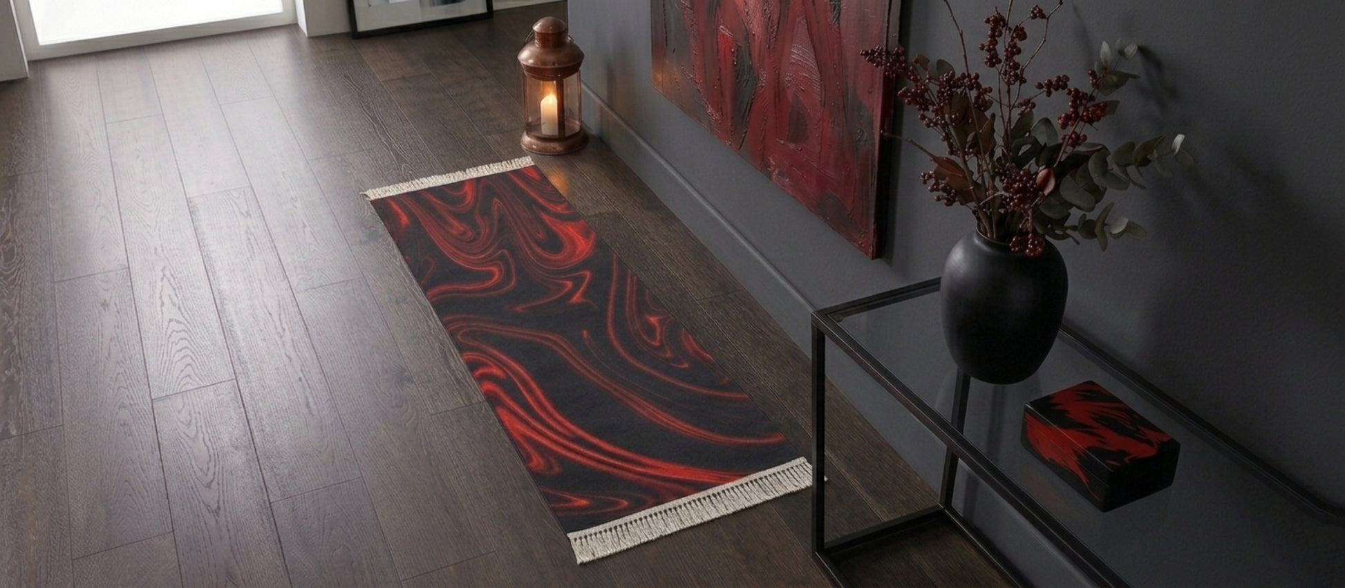 A narrow red and black marble runner rug in a moody hallway with dark grey walls, a copper lantern, and a glass console table with a black vase.