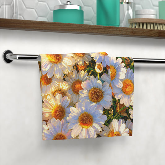 The Dawning Field hand and face towel with golden-hour daisy print hanging folded on a modern chrome towel bar.