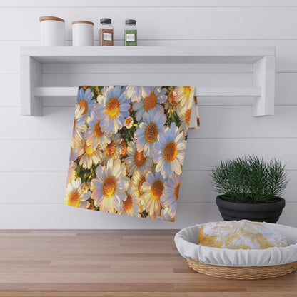 The Dawning Field daisy hand towel folded over a white hanging bar beside a basket of fresh bread on a kitchen counter.