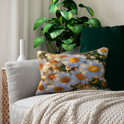 The Dawning Field Lumbar Pillow featuring white and golden daisies displayed on a cream armchair with a textured throw blanket.