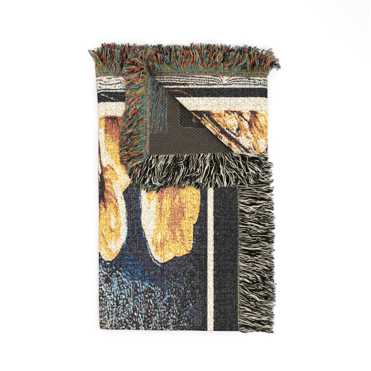 Folded view of The Garden Beyond the Winter woven art throw blanket with a turned corner highlighting the weave texture and fringes.