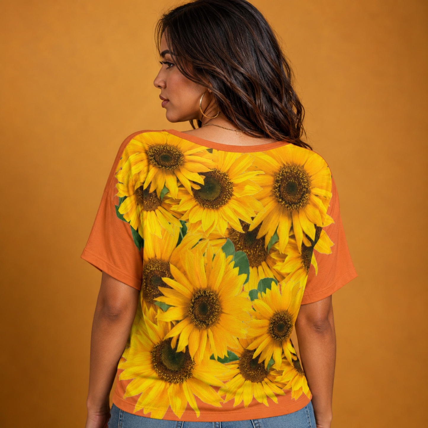 Back profile of a model showcasing the seamless sunflower print design on the vivid red tangelo batwing sleeve shirt.