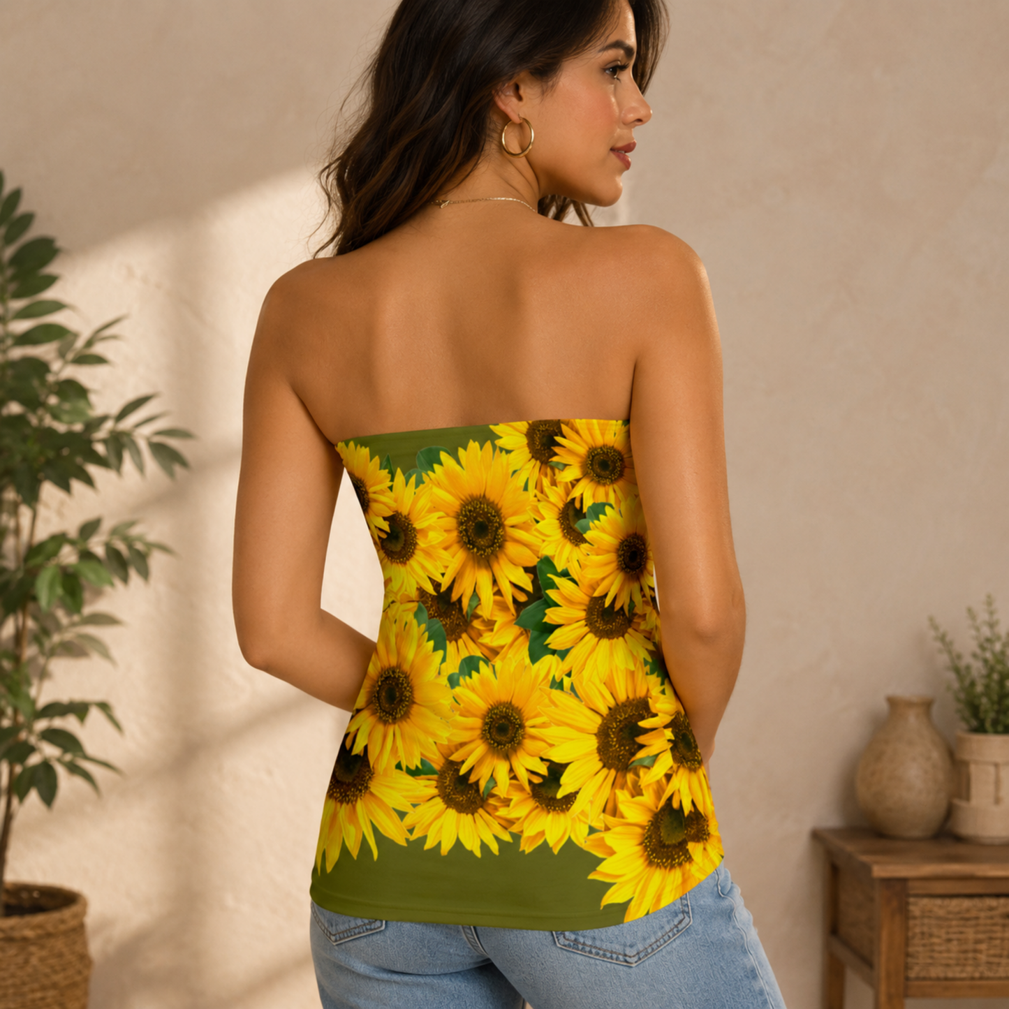 Back view of a woman wearing an olive green strapless tube top covered in a vivid yellow sunflower pattern.