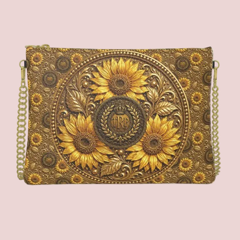 Front view of the textured leather crossbody bag showing a detailed, embossed central circular medallion with a TRP monogram logo and golden sunflowers.