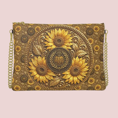 Front view of the textured leather crossbody bag showing a detailed, embossed central circular medallion with a TRP monogram logo and golden sunflowers.