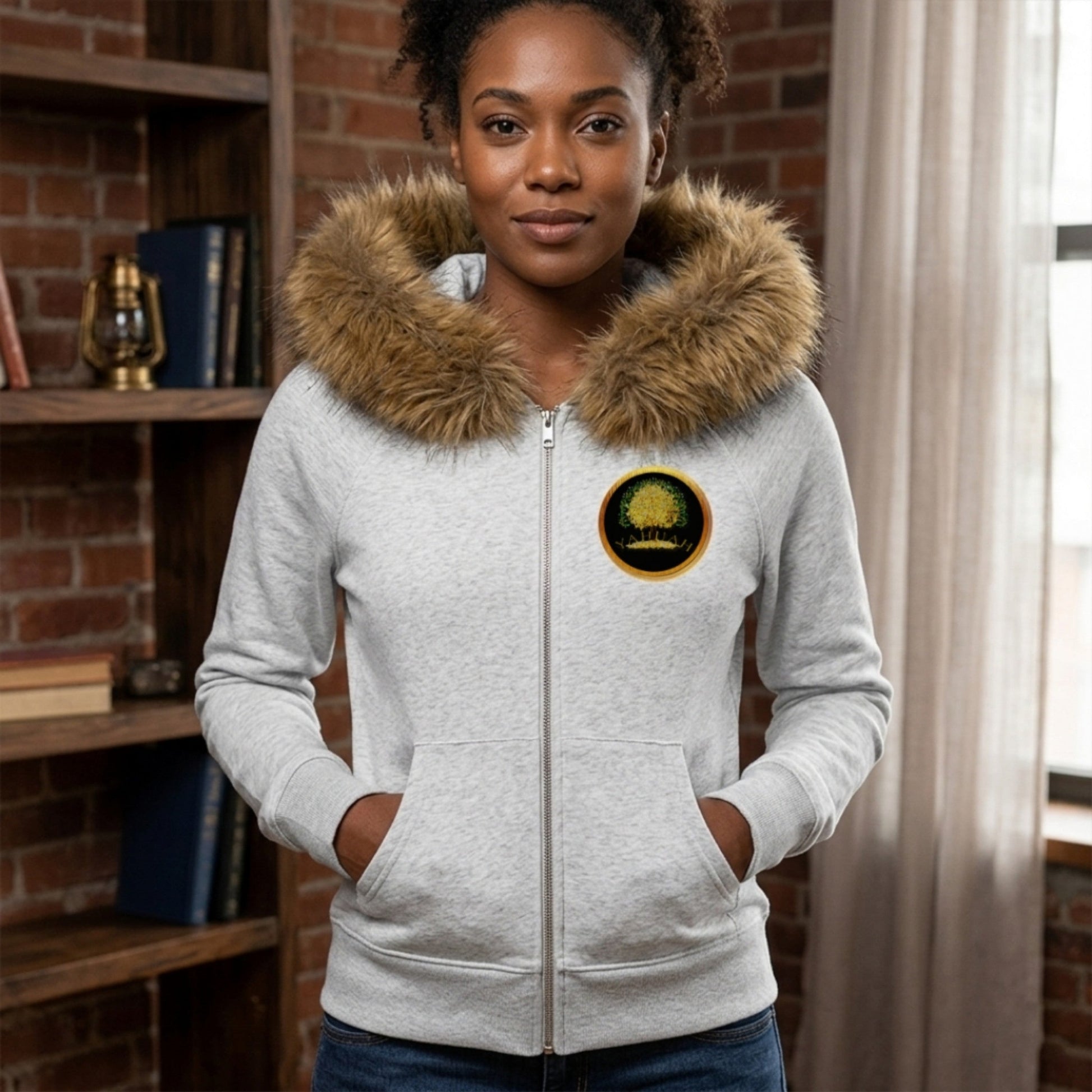 Front view of a woman in a grey faux fur trim hoodie, featuring the gold Yahuah Tree of Life emblem on the chest and a large graphic on the back.
