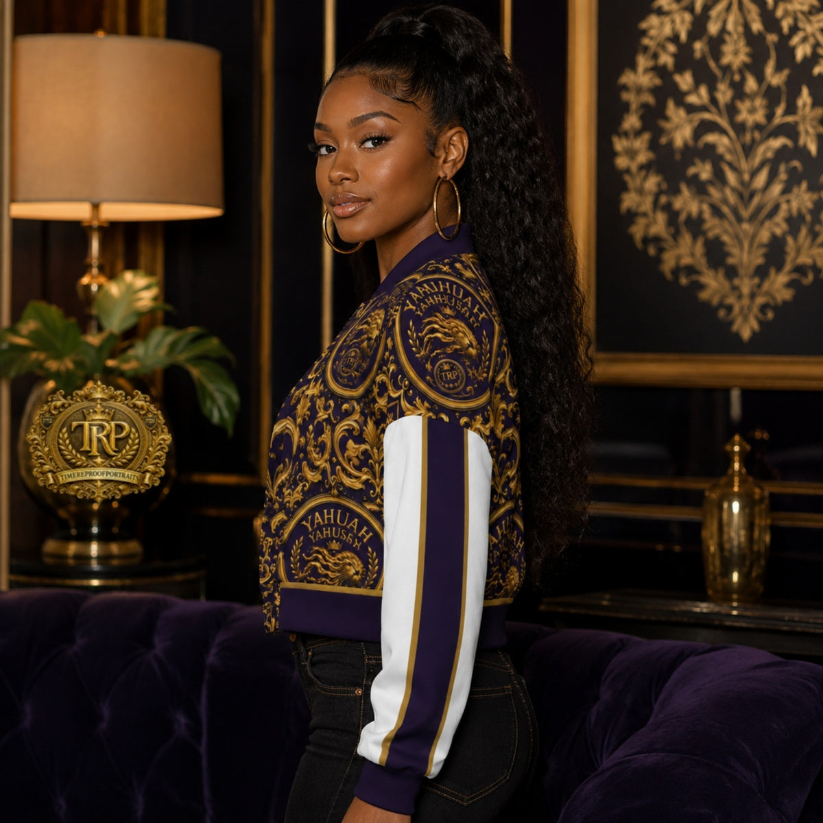 Left side view of a model wearing the purple and gold Yahuah Yahusha cropped drop-shoulder varsity jacket with striped sleeves.