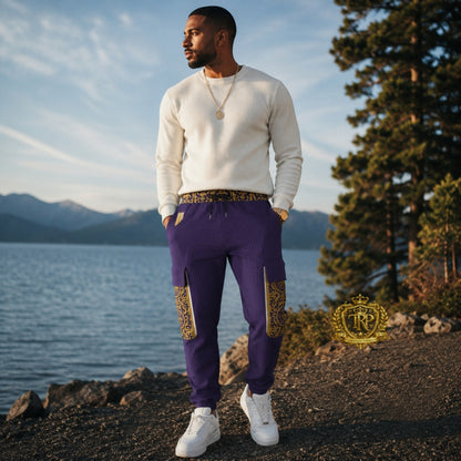 Front view of a man wearing purple Yahuah Yahusha lantern cargo joggers with patterned waist and gold trim side pockets.